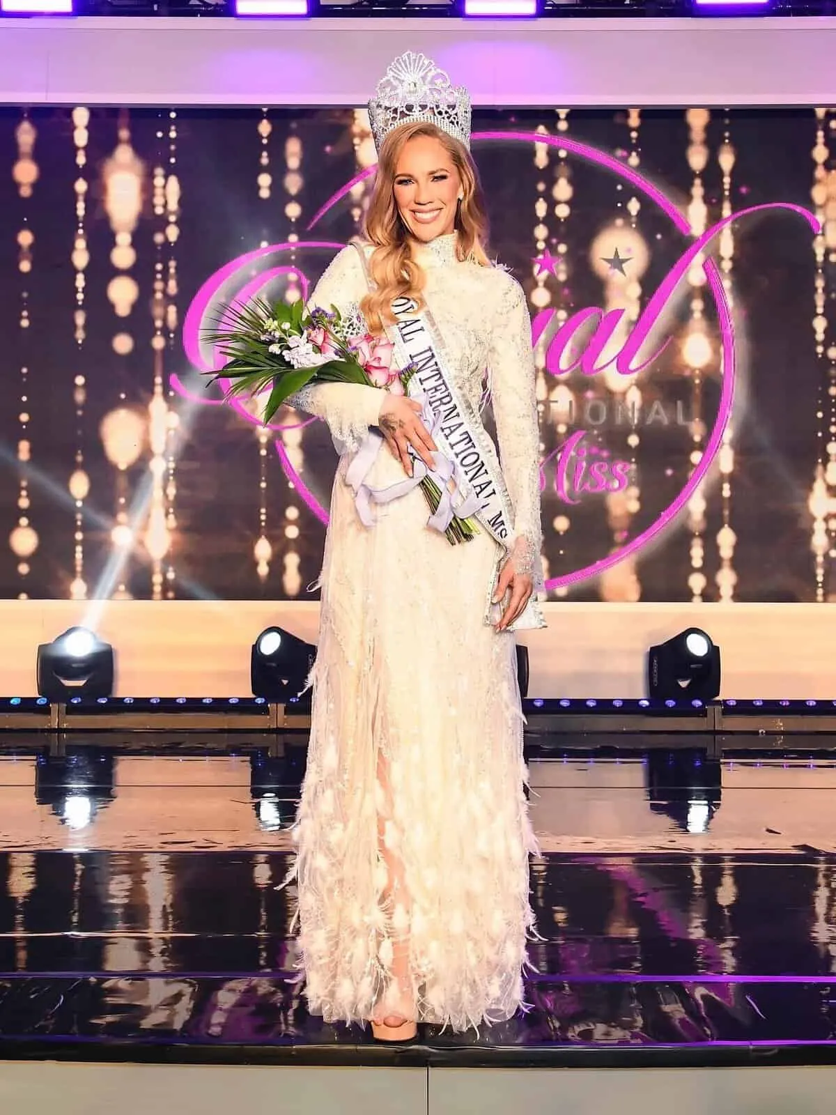 Bianca Andrews crowned on the Royal International Miss stage in Orlando, in an ivory lace gown