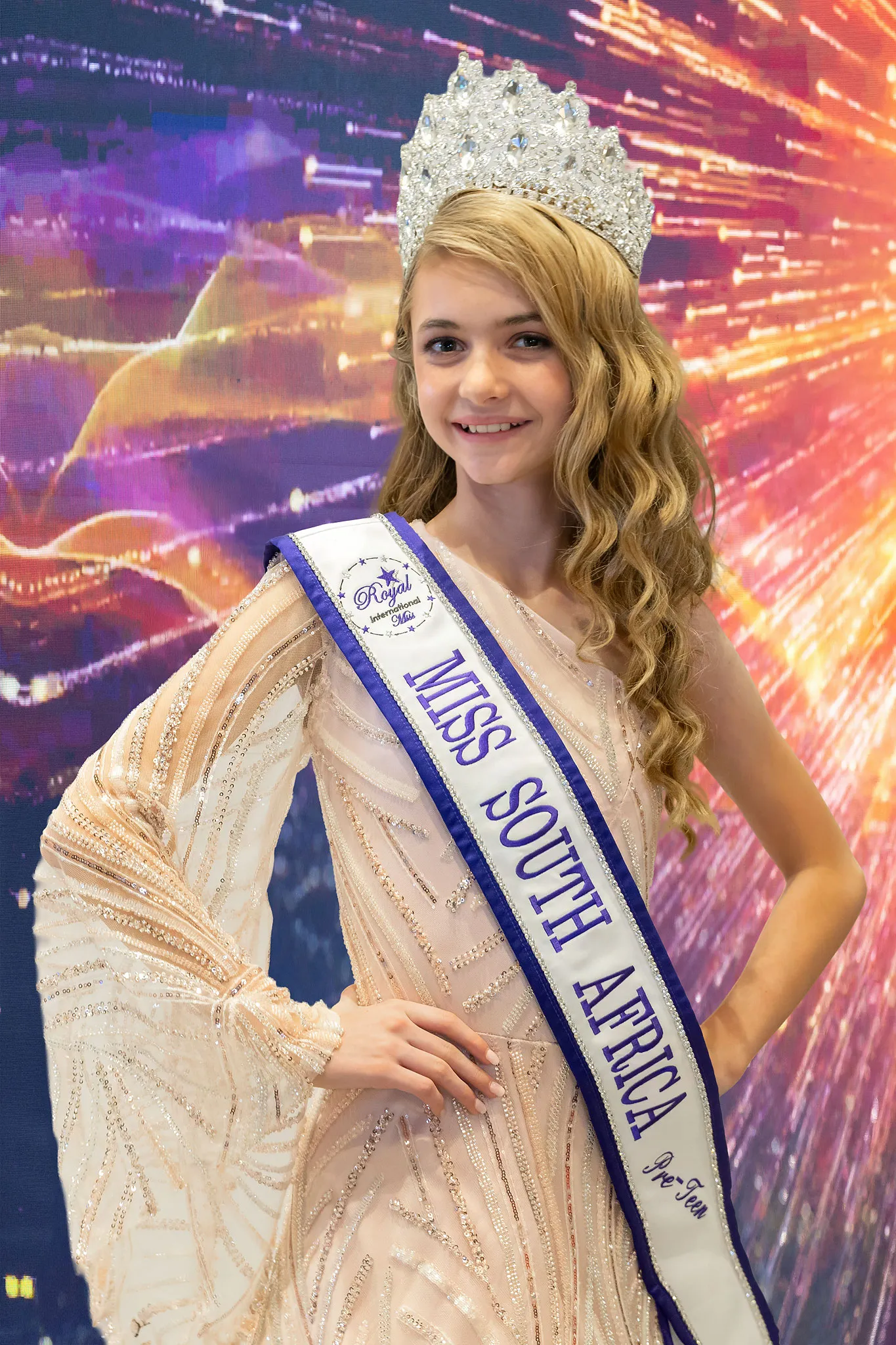 Lily Simpson crowned Pre-Teen, in a champagne beaded gown with flared sleeves