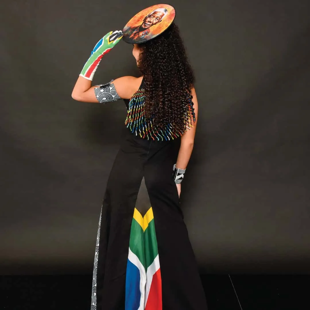 A South African delegate in a flag-print outfit with a hand-painted fan