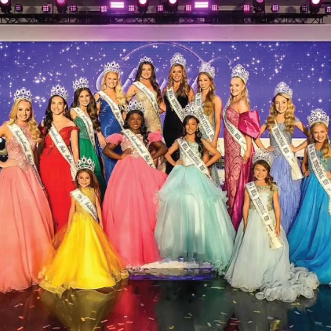 The crowned Queens of the international pageant in rows on stage
