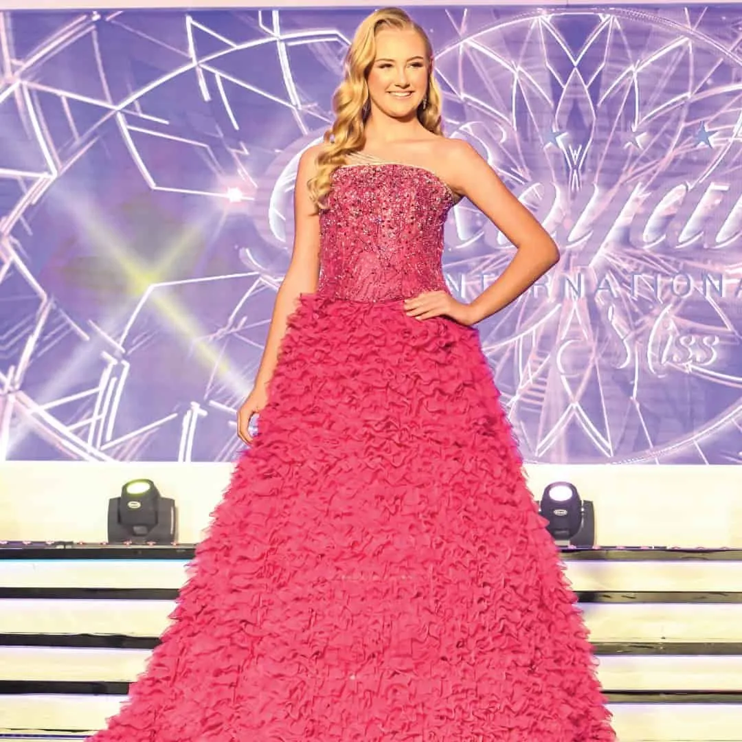 A delegate in a fuchsia ruffled ball gown on the international stage