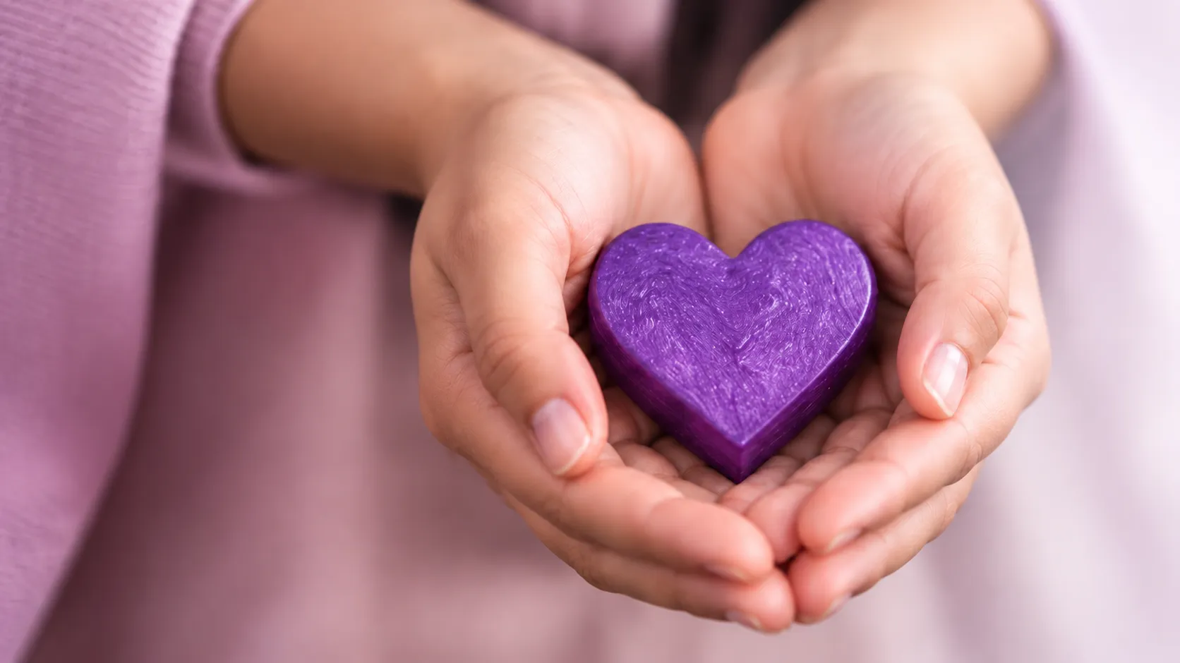 Cupped hands holding a purple heart